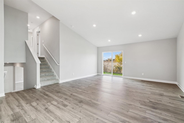 unfurnished living room with light hardwood / wood-style flooring and vaulted ceiling