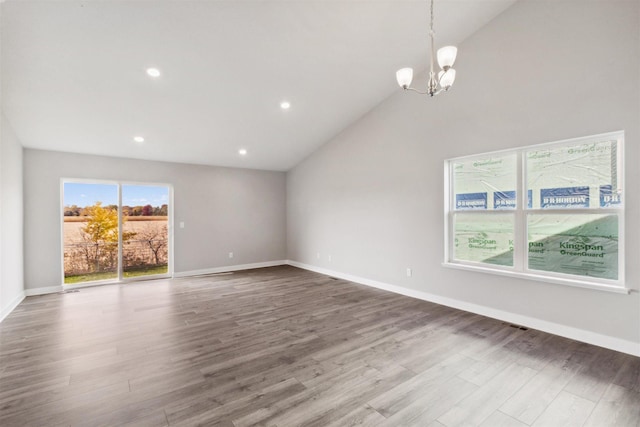 unfurnished living room with a chandelier, high vaulted ceiling, and wood-type flooring