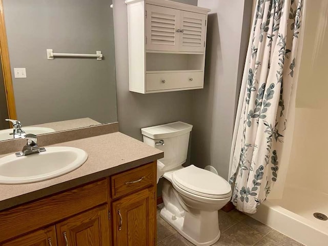 bathroom with curtained shower, toilet, vanity, and tile patterned flooring