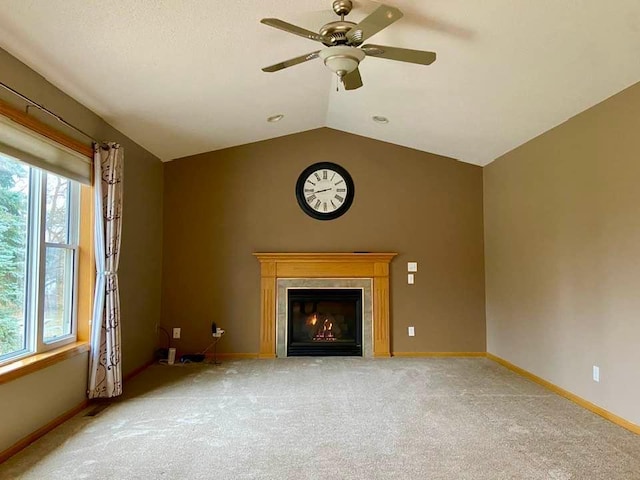 unfurnished living room with ceiling fan, light colored carpet, lofted ceiling, and a fireplace