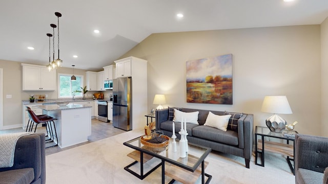 living room with light colored carpet, vaulted ceiling, and sink