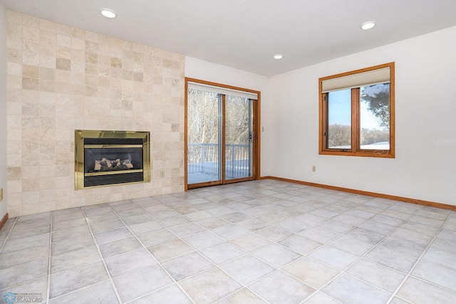 unfurnished living room with light tile patterned floors, tile walls, and a tiled fireplace