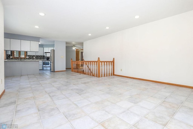 unfurnished living room with ceiling fan and light tile patterned flooring