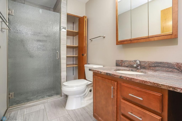 bathroom featuring vanity, toilet, and a shower with shower door