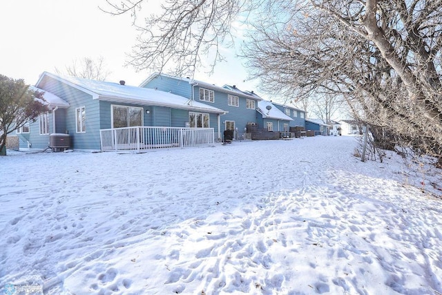 snow covered house with a deck and central air condition unit