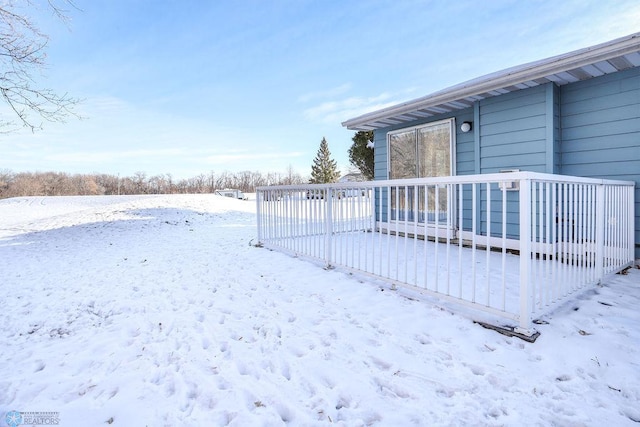 yard covered in snow with a deck