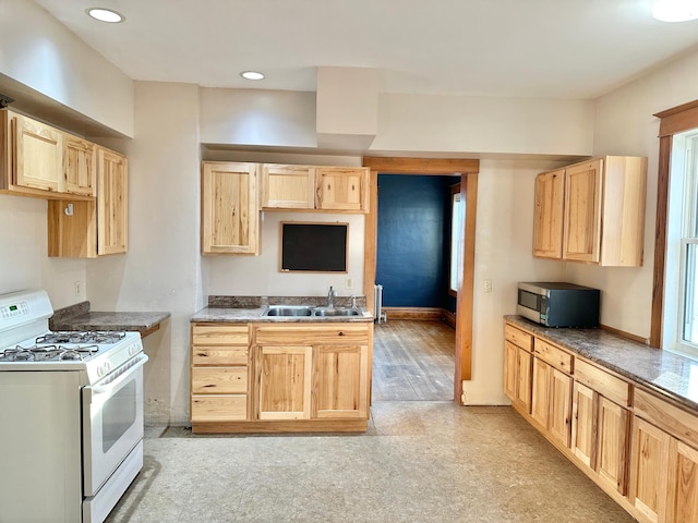 kitchen featuring light brown cabinets, sink, and white range with gas cooktop