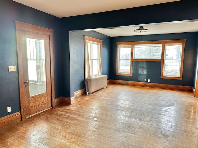 doorway with radiator heating unit and light wood-type flooring