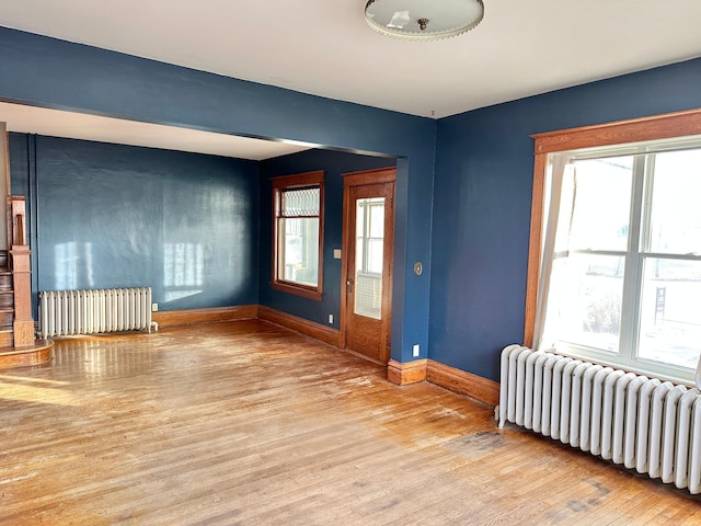 unfurnished room with radiator heating unit and light hardwood / wood-style floors