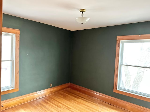 empty room with hardwood / wood-style floors and plenty of natural light