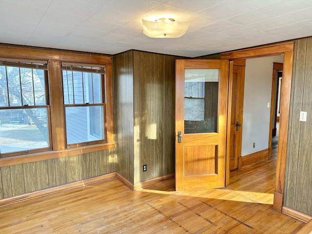 spare room featuring wooden walls and hardwood / wood-style floors