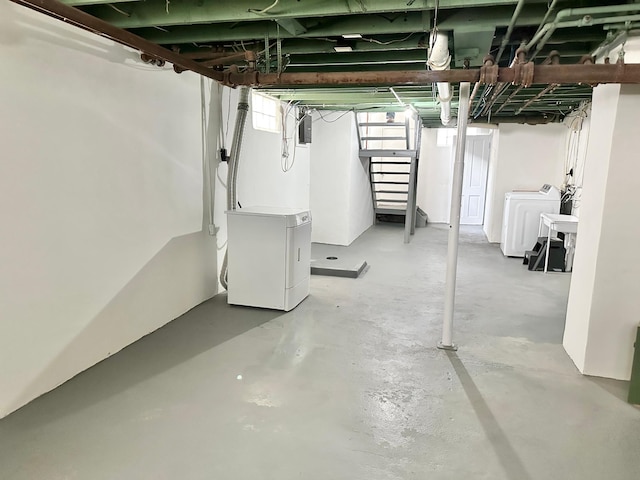 basement featuring washer and dryer, electric panel, and fridge