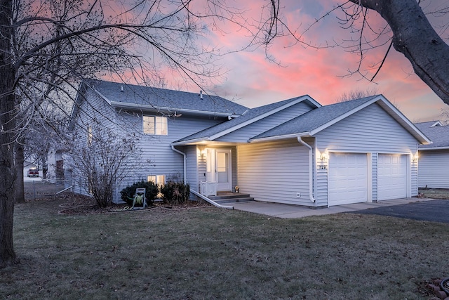 view of front of home featuring a lawn, a garage, and central AC