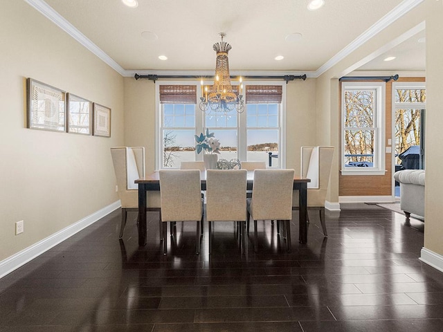 dining area featuring dark wood-type flooring, ornamental molding, and a notable chandelier