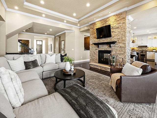 living room featuring crown molding, light hardwood / wood-style floors, and a stone fireplace