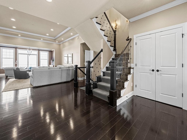 stairway featuring hardwood / wood-style flooring, a tray ceiling, and ornamental molding