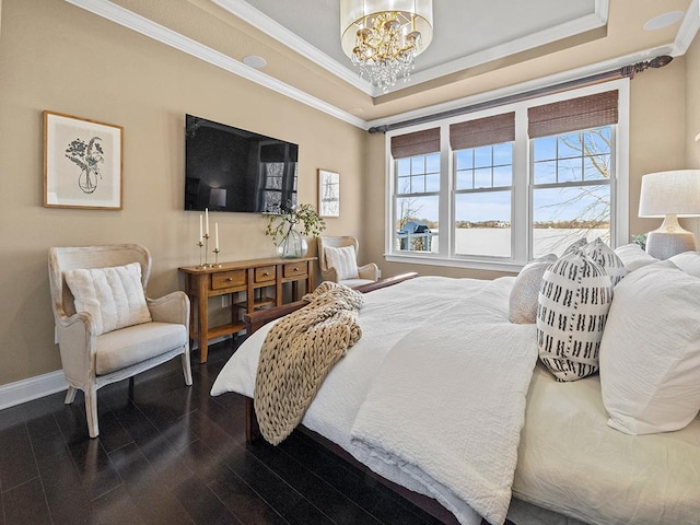 bedroom with dark wood-type flooring, a tray ceiling, a chandelier, and ornamental molding