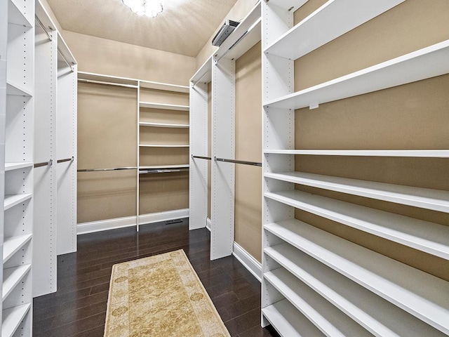 walk in closet with dark hardwood / wood-style flooring