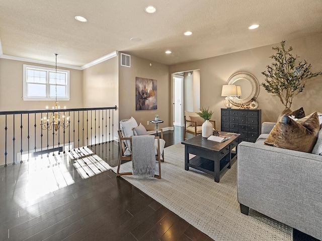 living room with hardwood / wood-style floors, ornamental molding, and a chandelier