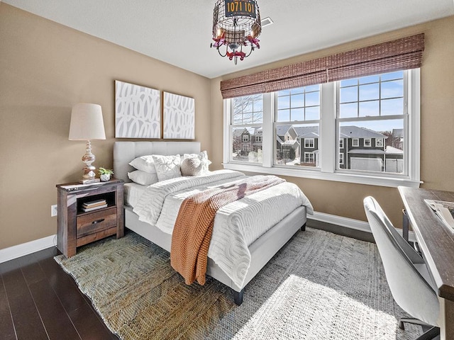 bedroom featuring dark hardwood / wood-style flooring and an inviting chandelier