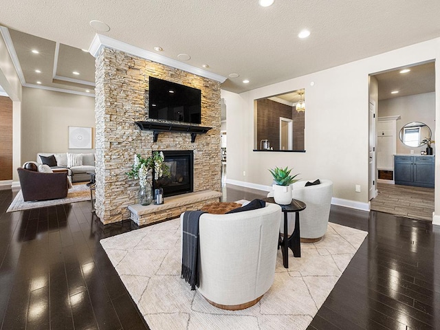 living room with light wood-type flooring, crown molding, a textured ceiling, and a stone fireplace