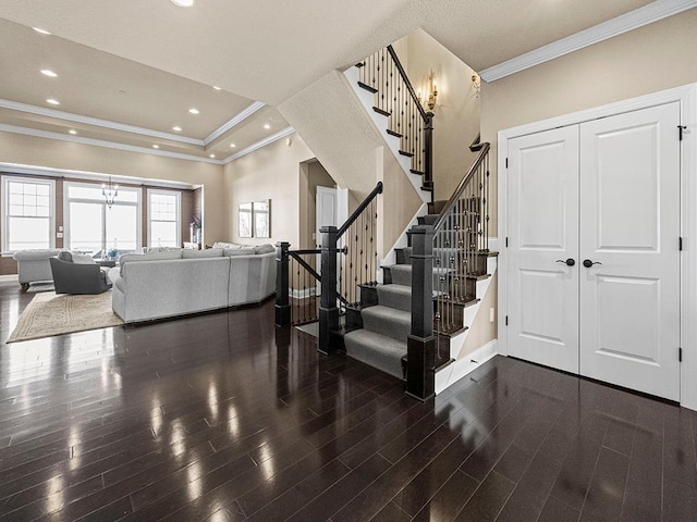 entryway featuring a raised ceiling, ornamental molding, and dark hardwood / wood-style floors