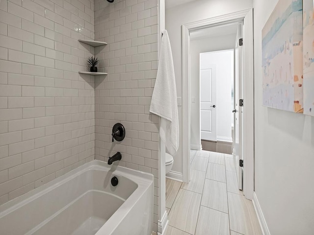 bathroom featuring toilet and tiled shower / bath