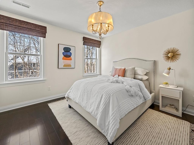 bedroom featuring hardwood / wood-style floors and a notable chandelier