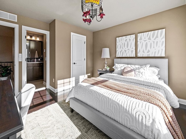 bedroom featuring connected bathroom and dark hardwood / wood-style flooring