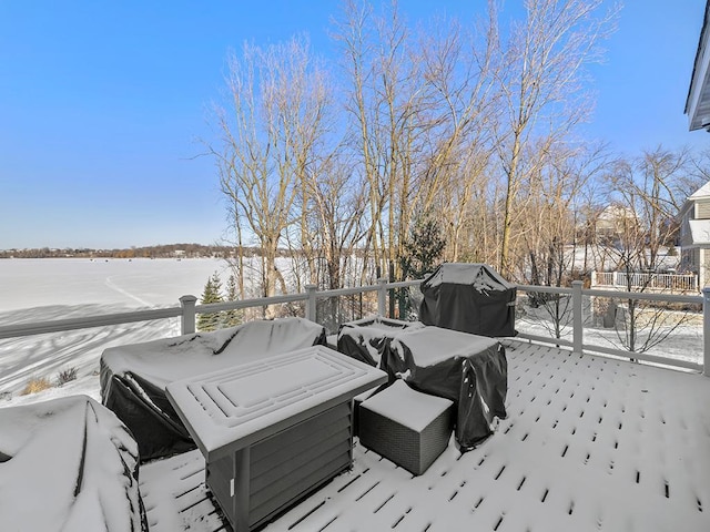 snow covered deck with a grill