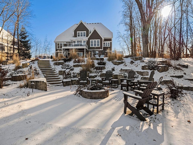 snow covered property with an outdoor fire pit