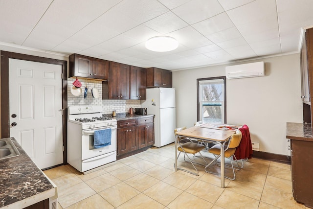 kitchen with sink, tasteful backsplash, a wall mounted AC, white appliances, and light tile patterned floors