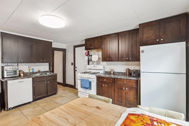 kitchen with dark brown cabinetry, sink, backsplash, white appliances, and light tile patterned flooring