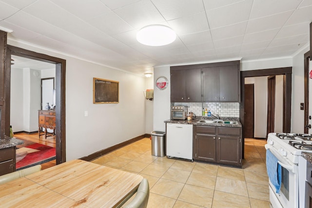 kitchen featuring backsplash, white appliances, dark brown cabinetry, sink, and light tile patterned floors