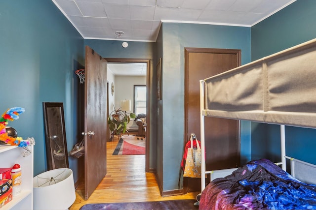 bedroom with crown molding and wood-type flooring