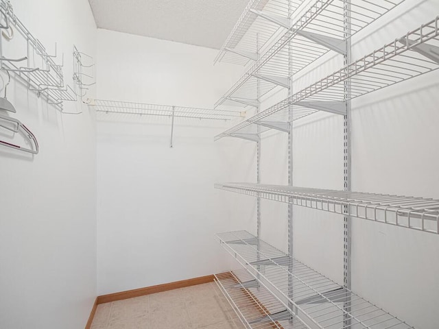 walk in closet with light tile patterned floors