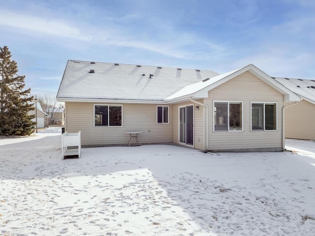 view of snow covered back of property