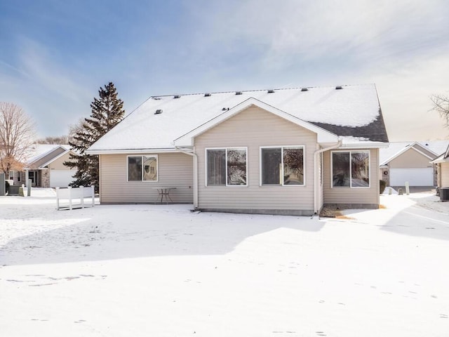 snow covered house featuring cooling unit