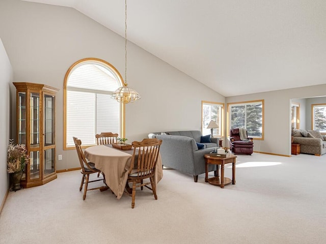 carpeted dining space featuring high vaulted ceiling and a notable chandelier