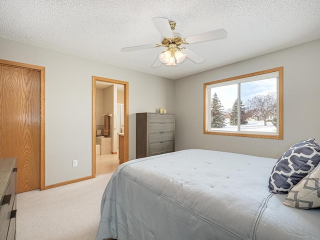 carpeted bedroom with ceiling fan, connected bathroom, and a textured ceiling