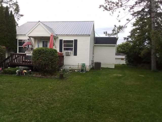 back of property with a yard, a wooden deck, and central air condition unit