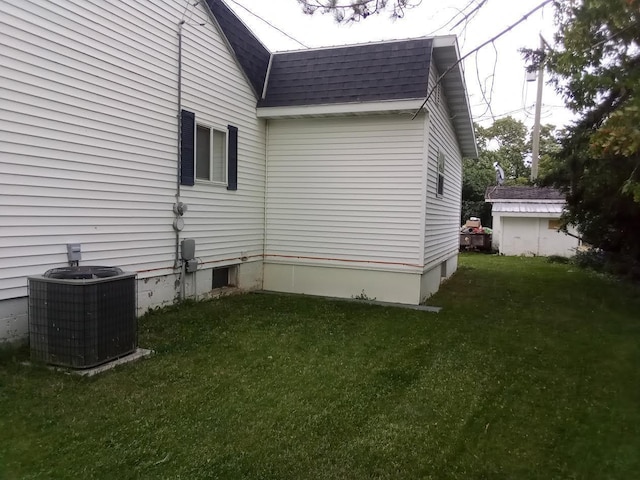 view of property exterior featuring central AC unit and a lawn