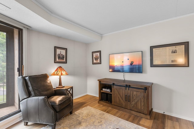 living area with hardwood / wood-style floors and crown molding