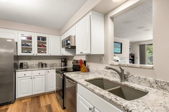 kitchen with white cabinetry, sink, stainless steel appliances, and a textured ceiling