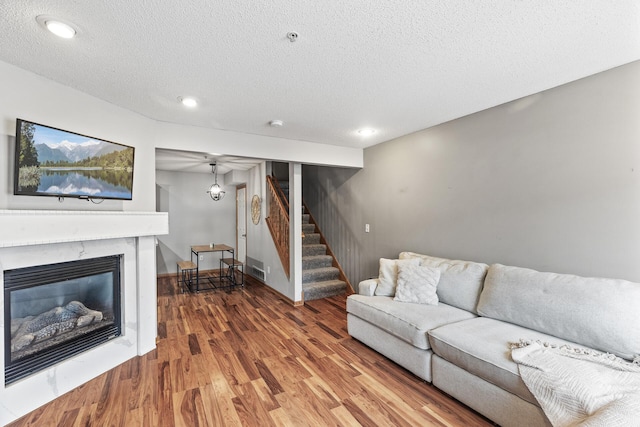 living room with wood-type flooring and a textured ceiling