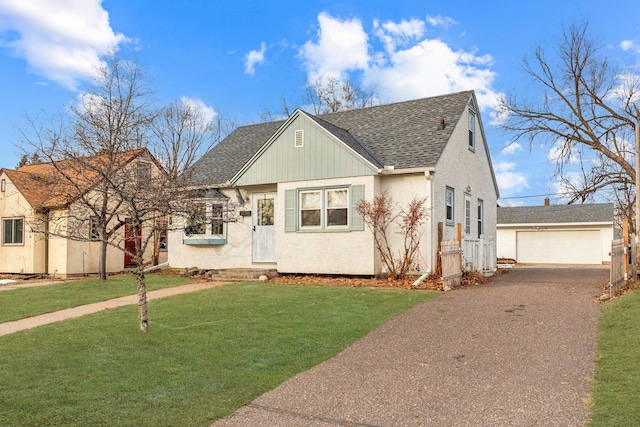 view of front facade with a garage, an outdoor structure, and a front yard