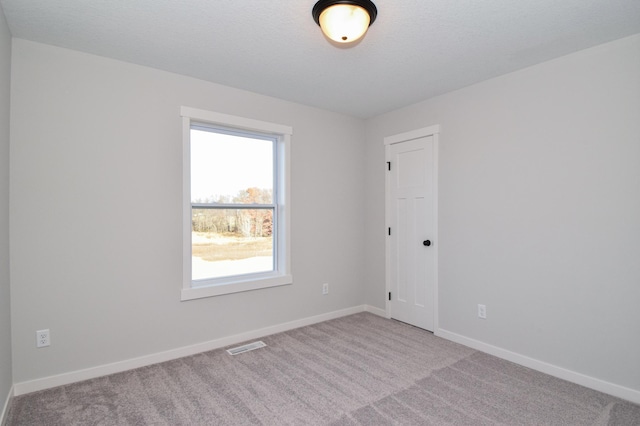 carpeted spare room with a textured ceiling