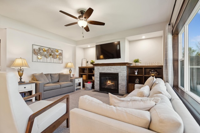 living room featuring a fireplace and ceiling fan