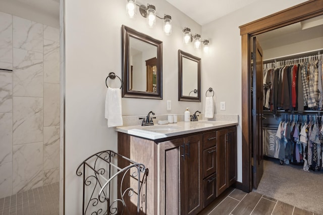 bathroom featuring a tile shower, vanity, and hardwood / wood-style floors