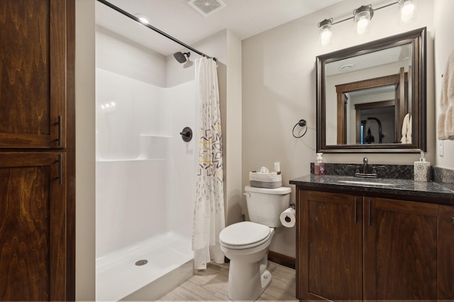 bathroom featuring a shower with shower curtain, vanity, and toilet